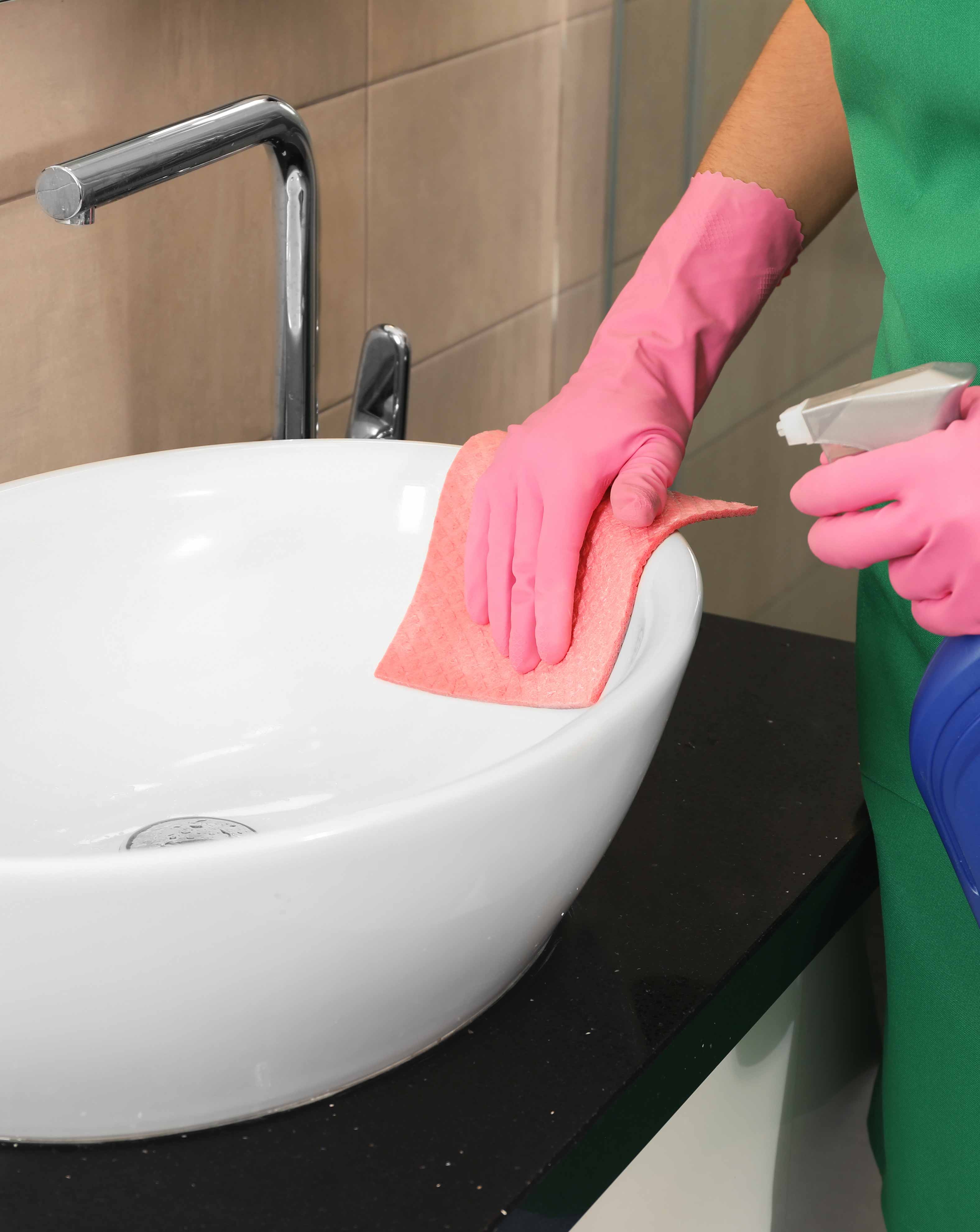 image of maid cleaning bathroom sink