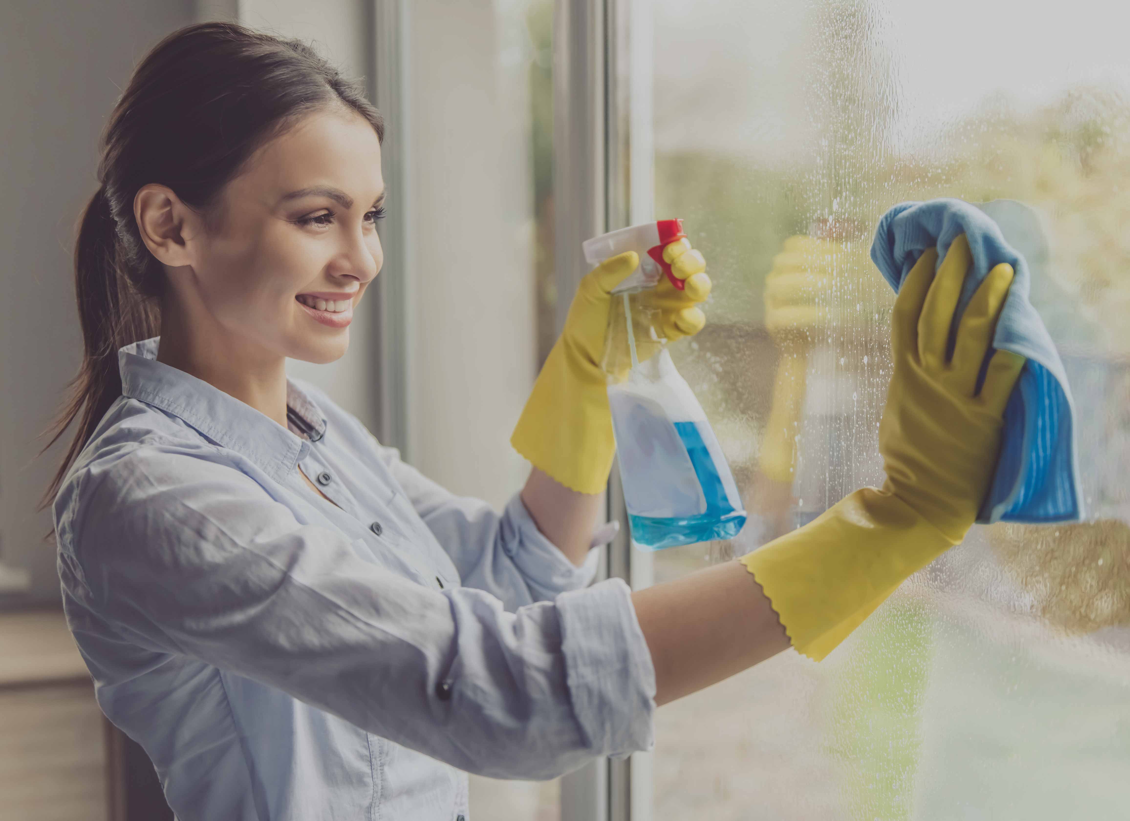 image of woman cleaning window.