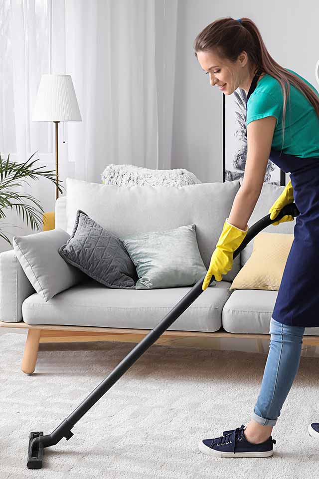 image of maid vacuuming carpet